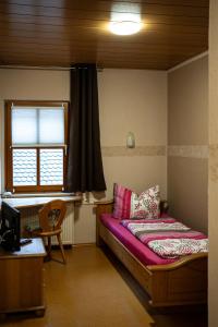 Habitación pequeña con cama y ventana en Cafe Alte Backstubn, en Spalt
