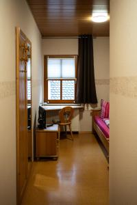 Habitación con cama, escritorio y ventana. en Cafe Alte Backstubn, en Spalt