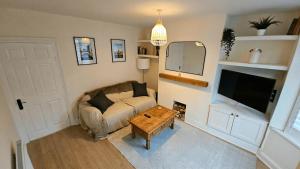 a living room with a couch and a coffee table at City Centre with Hot Tub - 3 Bed in Kent