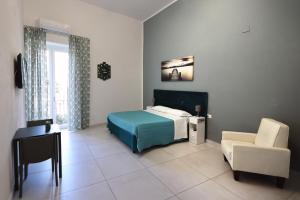 a bedroom with a bed and a desk and a chair at B&B La Cassa Armonica in Pozzuoli