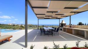 a patio with a table and chairs on a roof at Star Luxury Villa - Private pool, gym, playground in Kato Daratso