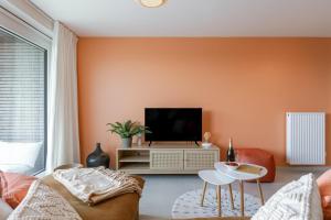 a living room with a couch and a tv at Flat Vigó in De Panne