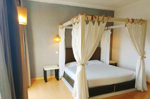 a bedroom with a canopy bed with white curtains at Casa Do Vale Hotel in Évora