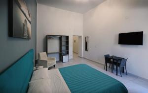sypialnia z łóżkiem, stołem i telewizorem w obiekcie B&B La Cassa Armonica w mieście Pozzuoli