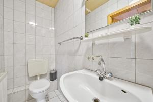 a white bathroom with a toilet and a bath tub at home2stay Apartmenthaus Deggendorf Wifi Smart TV Parking*** in Deggendorf