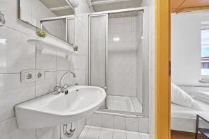 a white bathroom with a sink and a tub at home2stay Apartmenthaus Deggendorf Wifi Smart TV Parking*** in Deggendorf