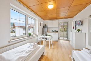 Habitación con cama y cocina con mesa en home2stay Apartmenthaus Deggendorf Wifi Smart TV Parking***, en Deggendorf