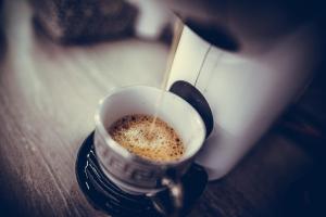 a person is pouring coffee into a cup on a table at Apartment Antique Theatre in Stara Zagora