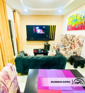 a living room with a green couch and a flat screen tv at LA GRANITA HOTEL AND SUITES in Ado Ekiti