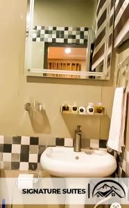 bagno con lavandino e specchio di LA GRANITA HOTEL AND SUITES a Ado Ekiti