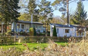 een wit huis met een hek ervoor bij Nice Home In Rheinsberg Ot Warenthi With Sauna in Warenthin