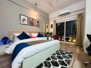 a bedroom with a large bed and a window at Sapphire Skies By BuddiesHome in Greater Noida