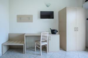 ein Zimmer mit Schreibtisch, Stuhl und Fernseher in der Unterkunft Hotel Tourist in Cefalú