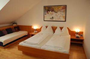 1 dormitorio con 2 camas, 2 lámparas y una pintura en Pension zur Post, en Bad Blumau