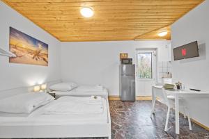 Camera con 2 letti, tavolo e frigorifero. di home2stay Monteur Apartmenthaus Deggendorf Wifi Smart TV Parking a Deggendorf