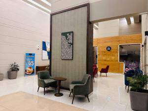 een wachtkamer met stoelen en een tafel in een gebouw bij Sapphire Skies By BuddiesHome in Greater Noida