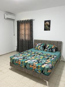 een bed met een kleurrijk dekbed in een slaapkamer bij App 2 chambres piscine privative 600m plage in Mezraya