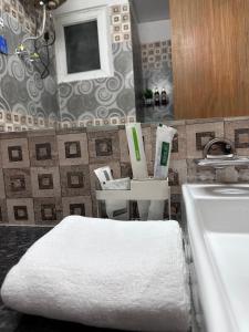 a bathroom with a sink and a white towel at Sapphire Skies By BuddiesHome in Greater Noida