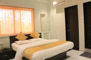 a bedroom with a large bed with a window at Hotel Pragati in Pune