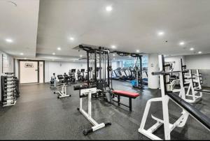 a gym with several tread machines in a room at Cozy 2 Bedroom Apartment Darling Harbour in Sydney