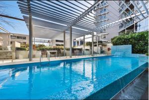 a large swimming pool with a canopy in a building at Cozy 2 Bedroom Apartment Darling Harbour in Sydney