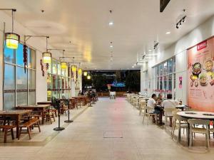 a restaurant with tables and chairs and people sitting at tables at Space Grey / Opposite IMAGO / KK City Center in Kota Kinabalu