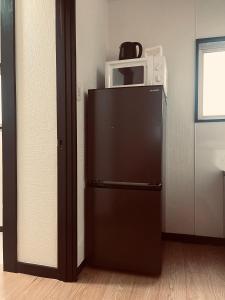 a microwave sitting on top of a refrigerator at home shinjuku west301 in Tokyo