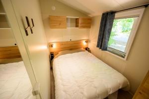 a small bedroom with two beds and a window at Les Eaux Chaudes in Digne-les-Bains