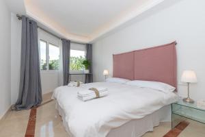 Łóżko lub łóżka w pokoju w obiekcie Lujoso Apartamento con piscina en Paseo Maritimo Marbella