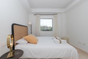 biała sypialnia z dużym łóżkiem i oknem w obiekcie Lujoso Apartamento con piscina en Paseo Maritimo Marbella w Marbelli +27 zdjęć