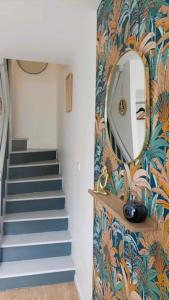 pasillo con escalera y espejo en la pared en Maison de ville - wifi - checkin autonome, en Saint-Martin-sur-Oust