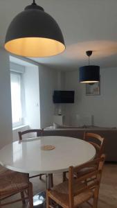 Un comedor con una mesa y sillas blancas. en Maison de ville - wifi - checkin autonome, en Saint-Martin-sur-Oust