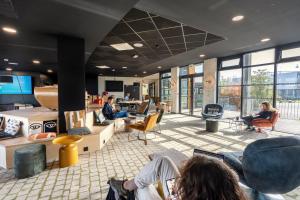 un groupe de personnes assises dans un hall dans l'établissement COWOOL TOULOUSE, à Toulouse