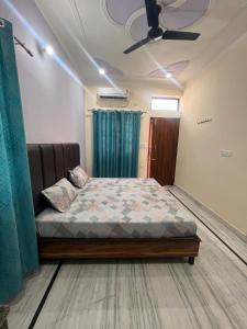 Bett in einem Zimmer mit Deckenventilator in der Unterkunft Deepak Homestay in Rishikesh