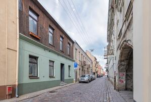 考纳斯Studio apartment Contrast By Polo Apartments的街道上拥有建筑和停车场的街道