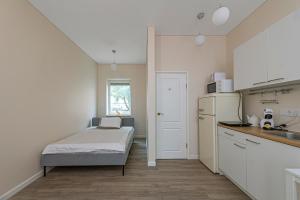 考纳斯Studio apartment Contrast By Polo Apartments的一间带床和冰箱的小厨房 更多8张照片