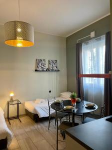 a room with a bed and a table with chairs at Bnbook Residence La Red in Rho
