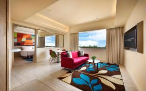 ein Wohnzimmer mit einem roten Sofa und einem Tisch in der Unterkunft Genting Hotel Jurong in Singapur