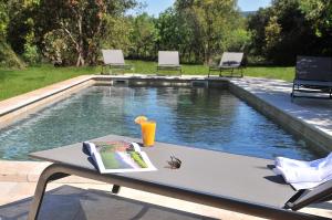 a table with a book on it next to a swimming pool at Château de Berne in Lorgues