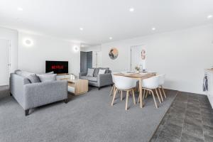 a living room with a table and chairs at Modern Retreat with King Bed - By KOSH BNB in Hamilton +15 photos