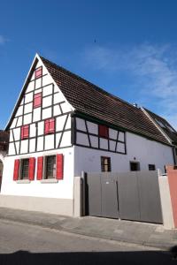 a white and red building with red shutters at Charmantes Fachwerkhaus mit Stil in Altrip
