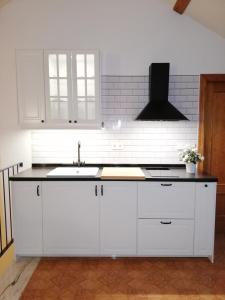 una cocina con armarios blancos y fregadero en Ático con vistas a la ciudad, en Ontinyent