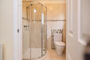a bathroom with a shower and a toilet at The Enfield Place - Elegant 4BDR House with Garden in Winchmore Hill