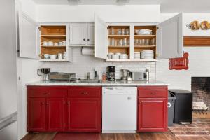 a kitchen with red cabinets and a white refrigerator at Federal on Exeter Circa 1805 Sleeps 8 in Exeter