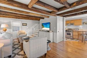 a kitchen and living room with white walls and wooden ceilings at Circa 1789 Historic South End Downtown Home in Newburyport