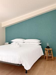 a bedroom with a white bed with a blue wall at Villa Ramadia in Floridia