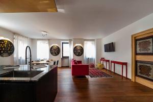 cocina grande y sala de estar con silla roja en Italianflat - Duomo Deluxe en Verona