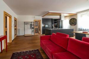 sala de estar con sofá rojo y cocina en Italianflat - Duomo Deluxe en Verona