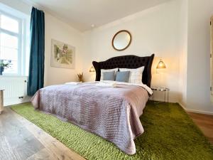a bedroom with a large bed with a green rug at Residence Charles Bridge in Prague