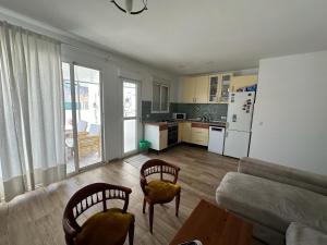 a living room with a couch and chairs and a kitchen at ATICO AMPLIO Y LUMINOSO in Seville